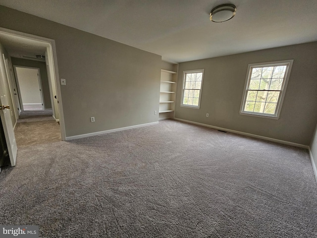 spare room with carpet floors and built in features