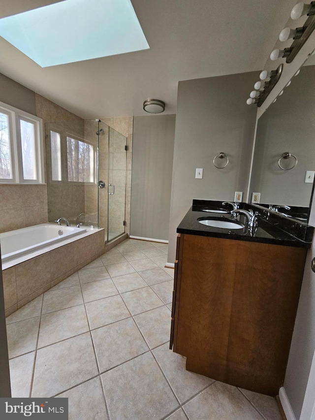 bathroom with tile patterned flooring, vanity, a skylight, and plus walk in shower