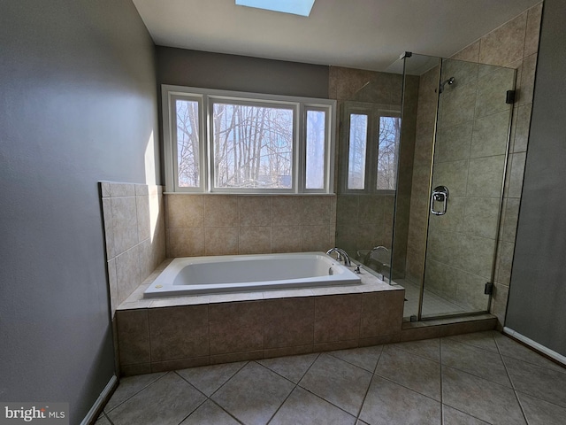 bathroom featuring plus walk in shower, a skylight, and tile patterned flooring