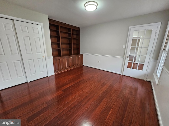 unfurnished bedroom with dark hardwood / wood-style flooring and a closet