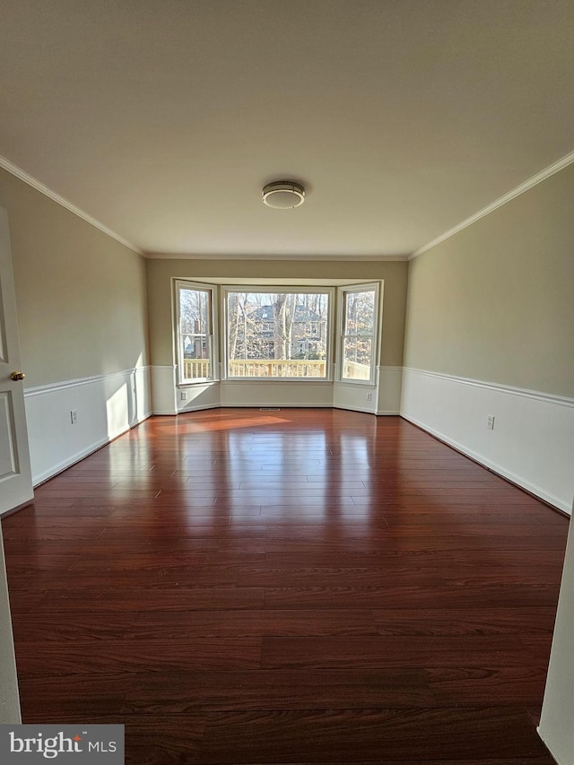 spare room featuring crown molding and dark hardwood / wood-style floors