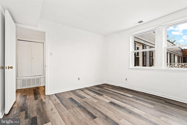 unfurnished room with dark wood-type flooring