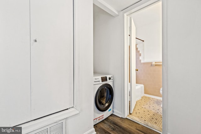 clothes washing area with tile walls, washer / dryer, and dark wood-type flooring