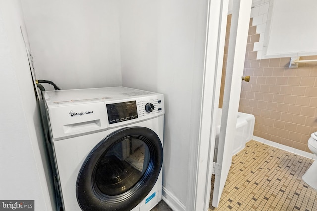 laundry room featuring tile patterned floors, washer / dryer, and tile walls