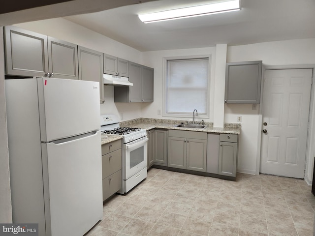 kitchen featuring light stone countertops, sink, gray cabinetry, and white appliances