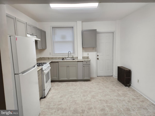 kitchen with radiator, white appliances, sink, gray cabinetry, and light stone counters