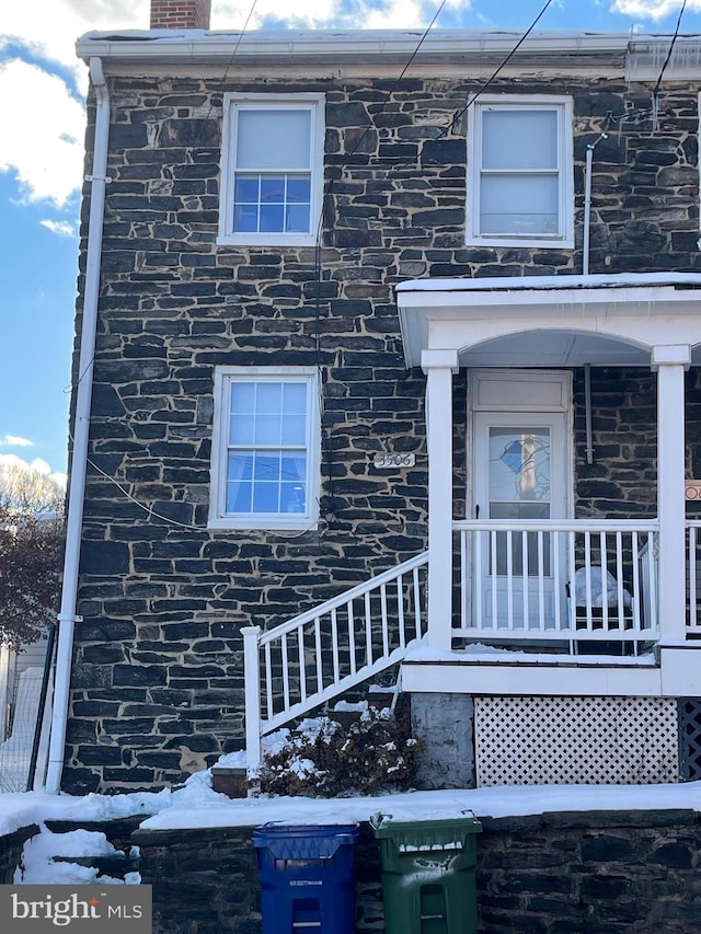 view of front facade featuring stone siding and a chimney