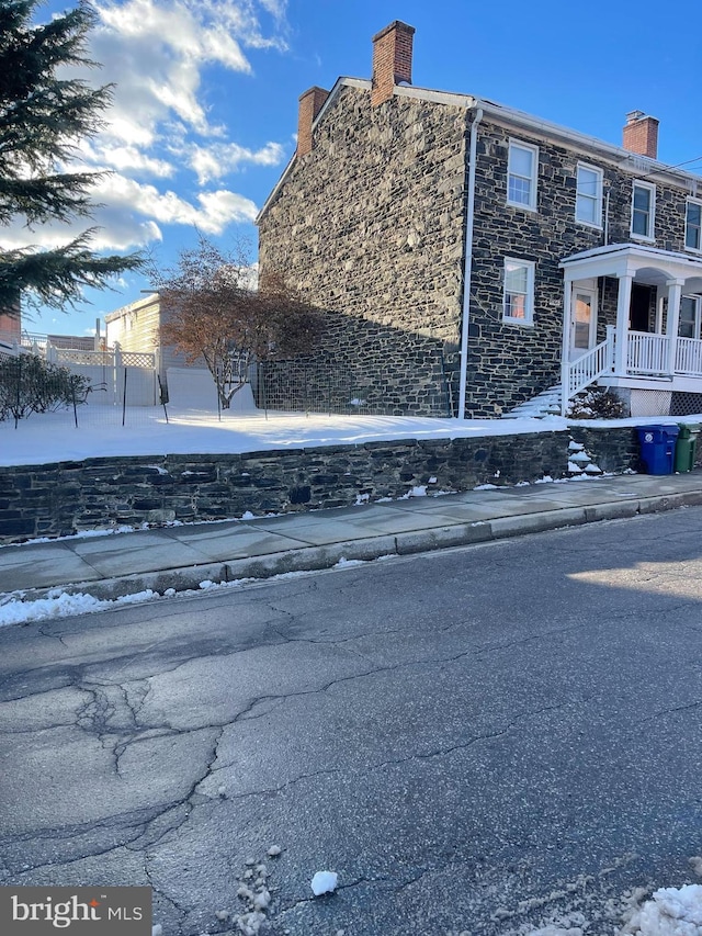 view of property exterior featuring stone siding and a chimney