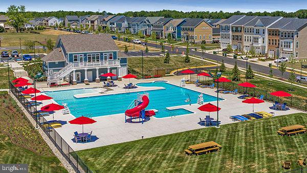 view of swimming pool with a patio, a water slide, and a yard