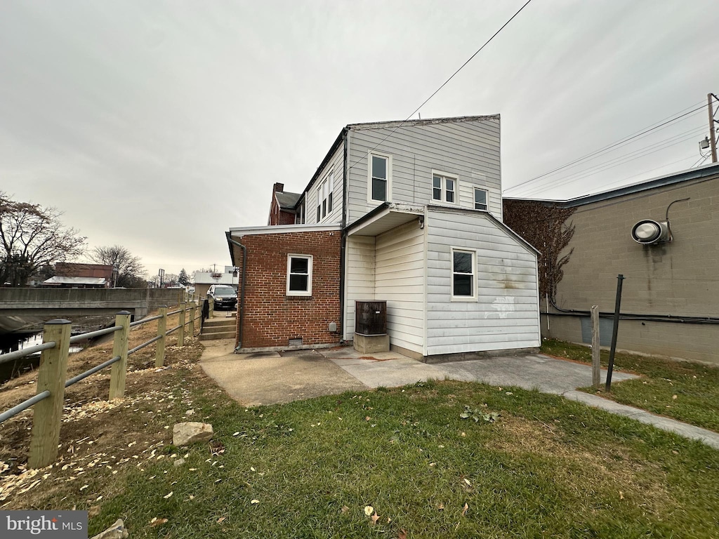 back of house with a yard and a patio