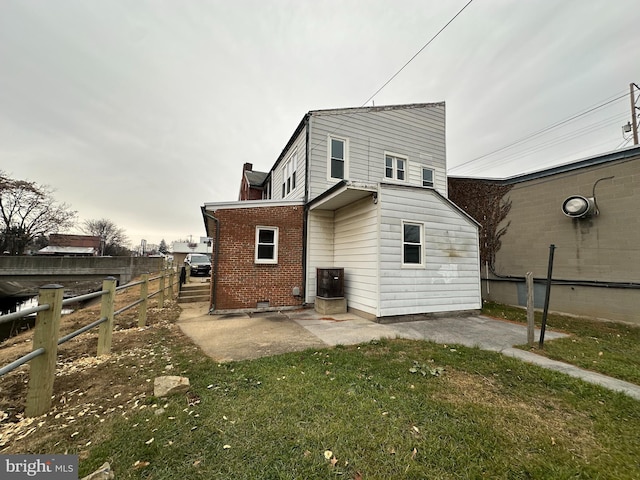 back of house with a yard and a patio