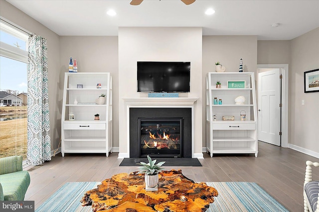 living room with wood-type flooring and ceiling fan