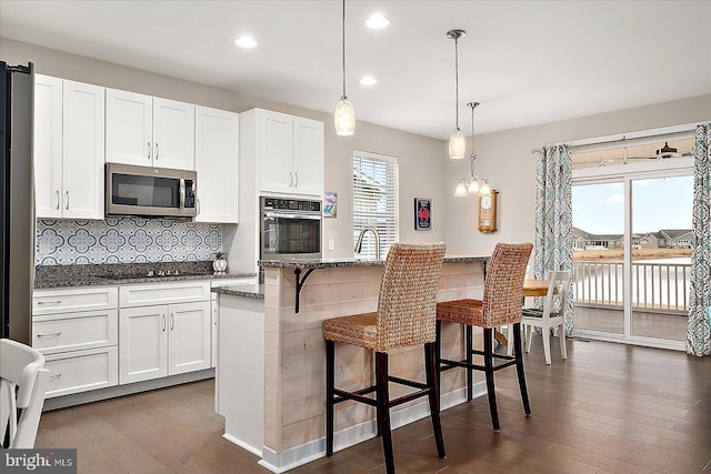 kitchen featuring appliances with stainless steel finishes, a center island, a breakfast bar area, and white cabinets