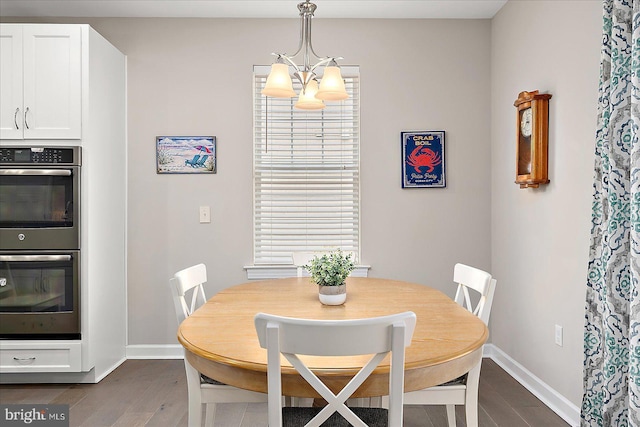 dining room with dark hardwood / wood-style flooring and a chandelier