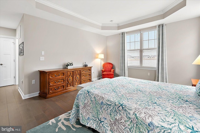 bedroom featuring dark hardwood / wood-style floors, ornamental molding, and a raised ceiling