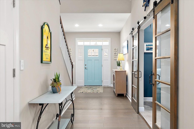 foyer featuring wood-type flooring and a barn door