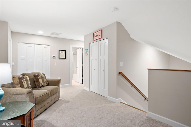 living room with vaulted ceiling and light colored carpet