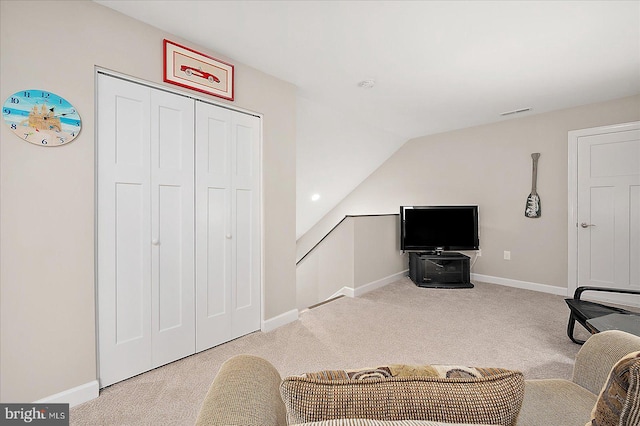 sitting room featuring lofted ceiling and light colored carpet