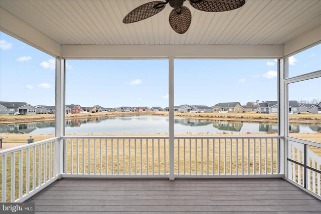 unfurnished sunroom with a water view and ceiling fan