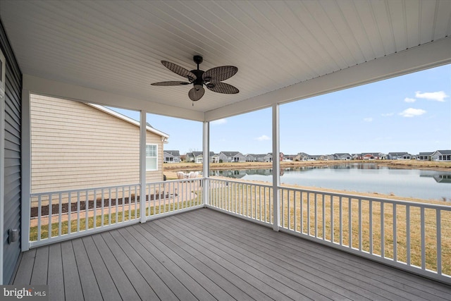 unfurnished sunroom featuring a water view and ceiling fan