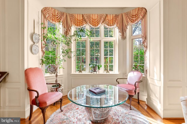 sitting room featuring wood finished floors and a decorative wall