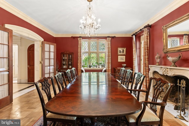 dining area with arched walkways, crown molding, and an inviting chandelier