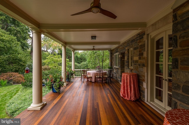 wooden deck with outdoor dining space, french doors, and ceiling fan