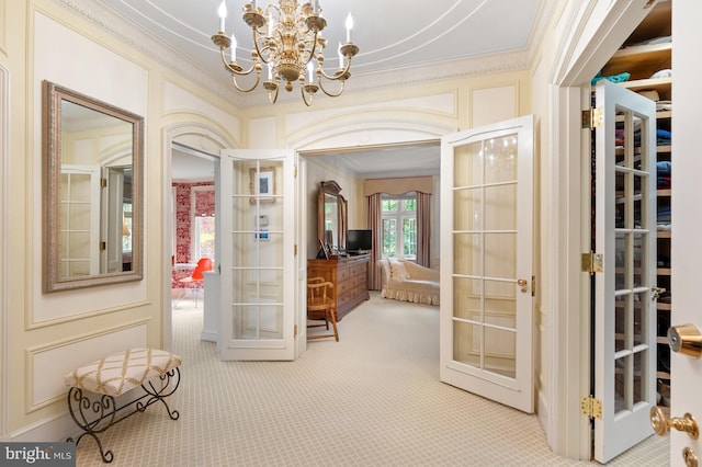 interior space with an inviting chandelier, crown molding, carpet flooring, and french doors