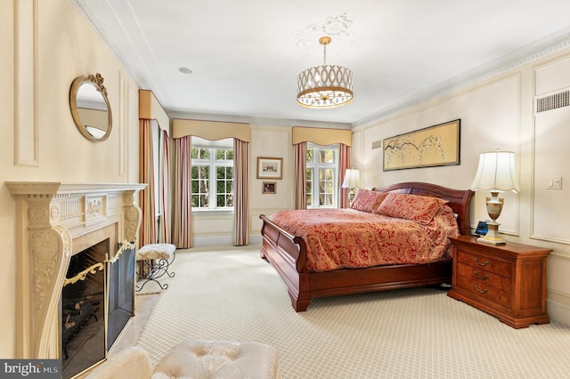 bedroom featuring light carpet, a premium fireplace, ornamental molding, an inviting chandelier, and a decorative wall