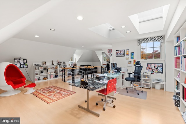 office space featuring recessed lighting, vaulted ceiling with skylight, and wood finished floors