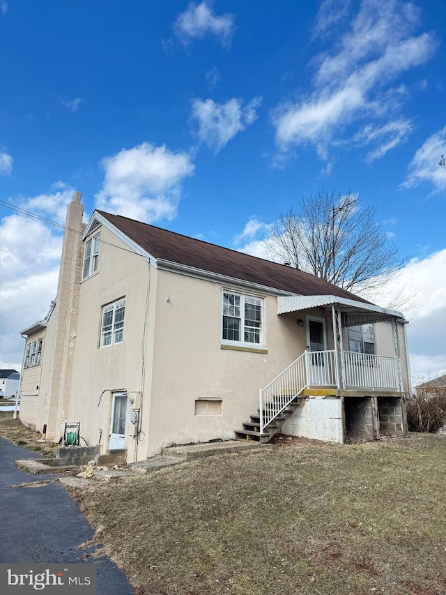 rear view of property with a lawn