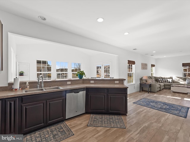 kitchen featuring sink, stainless steel dishwasher, dark brown cabinetry, and light hardwood / wood-style flooring