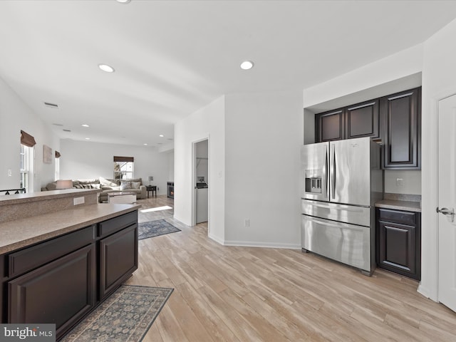 kitchen featuring dark brown cabinetry, stainless steel fridge with ice dispenser, and light wood-type flooring