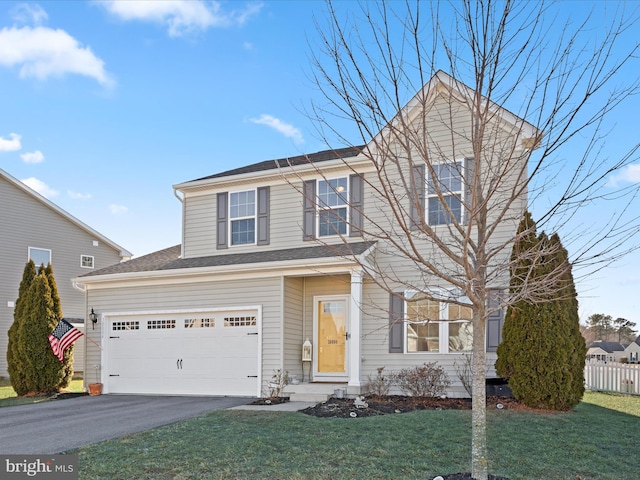 view of property with a garage and a front lawn