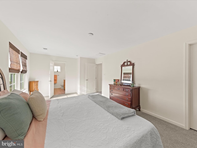 carpeted bedroom featuring ensuite bathroom