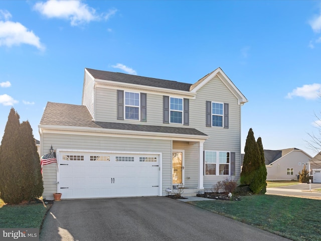 front facade featuring a garage and a front lawn