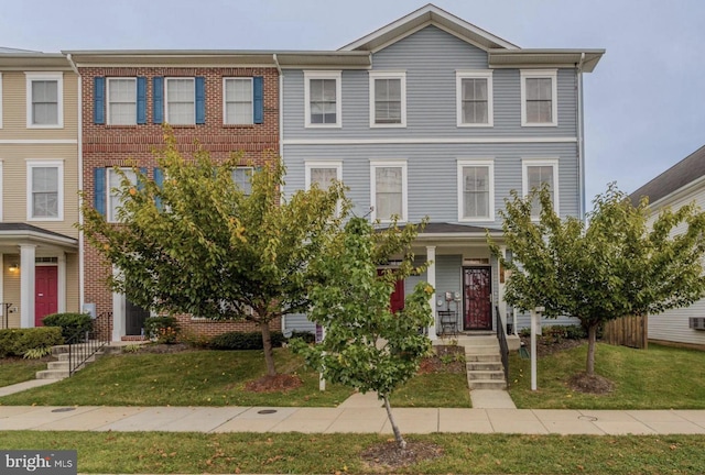 townhome / multi-family property with a front yard