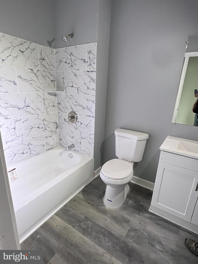 full bathroom with tiled shower / bath, wood-type flooring, vanity, and toilet