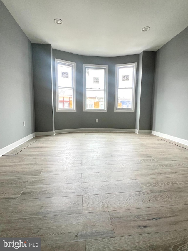 unfurnished room featuring a wealth of natural light and light hardwood / wood-style floors