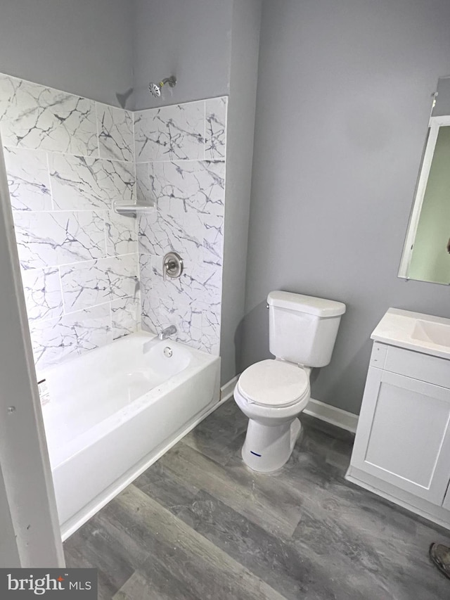 full bathroom featuring tiled shower / bath, vanity, toilet, and wood-type flooring