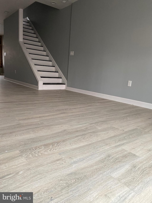 basement with light hardwood / wood-style flooring