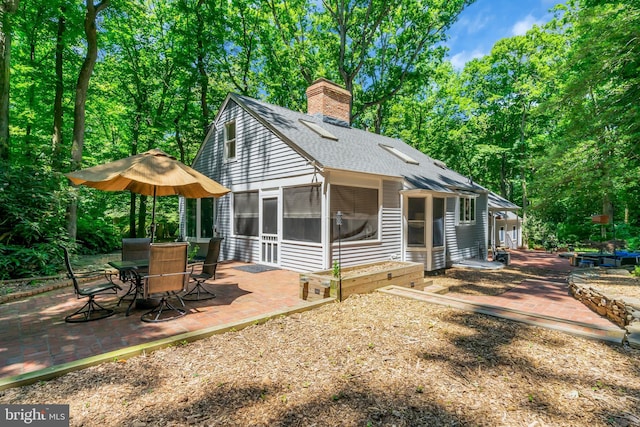 back of property with a patio area and a sunroom