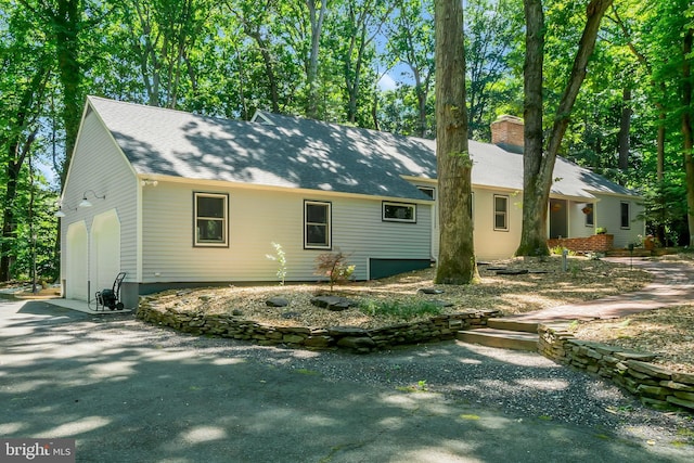 rear view of property with a garage