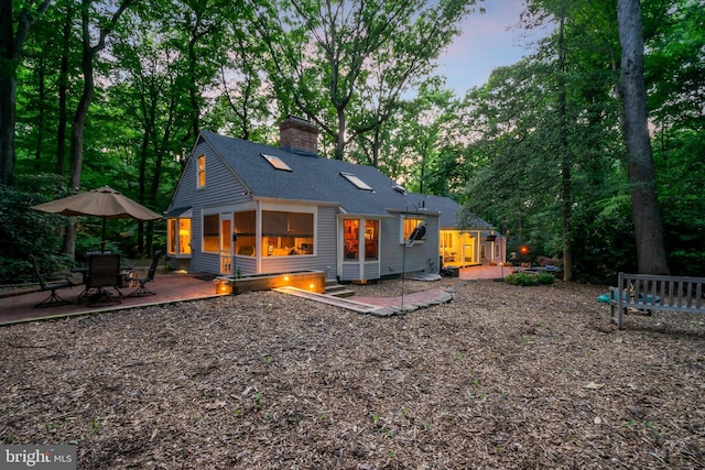 back house at dusk with a patio