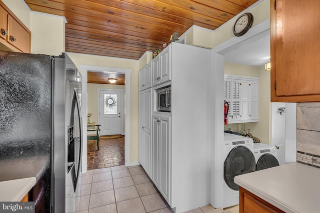 kitchen with washer and dryer, stainless steel microwave, white cabinets, black fridge with ice dispenser, and wooden ceiling