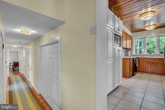 corridor with light tile patterned flooring and wooden ceiling