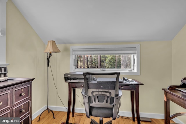 office area with light hardwood / wood-style flooring and vaulted ceiling