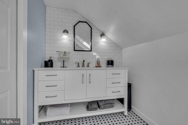 bathroom featuring tasteful backsplash, vanity, and vaulted ceiling