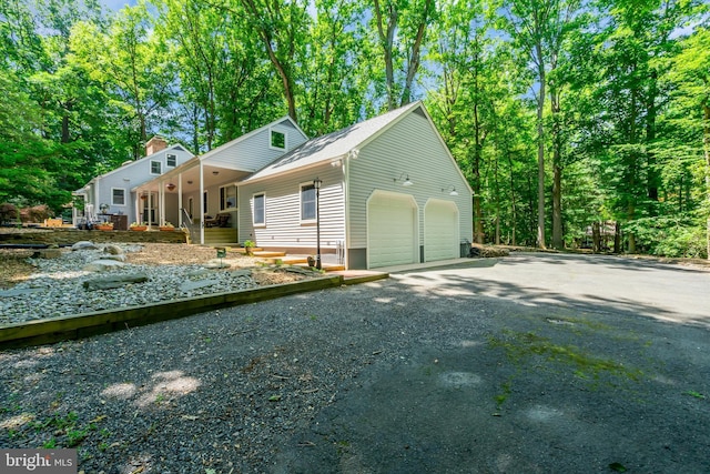 view of side of home with a garage and covered porch