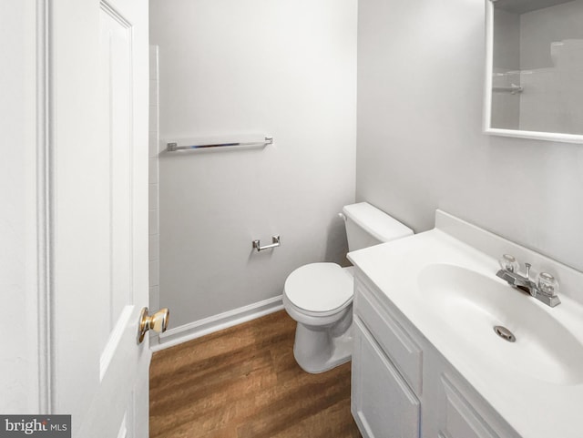 bathroom featuring vanity, hardwood / wood-style flooring, and toilet